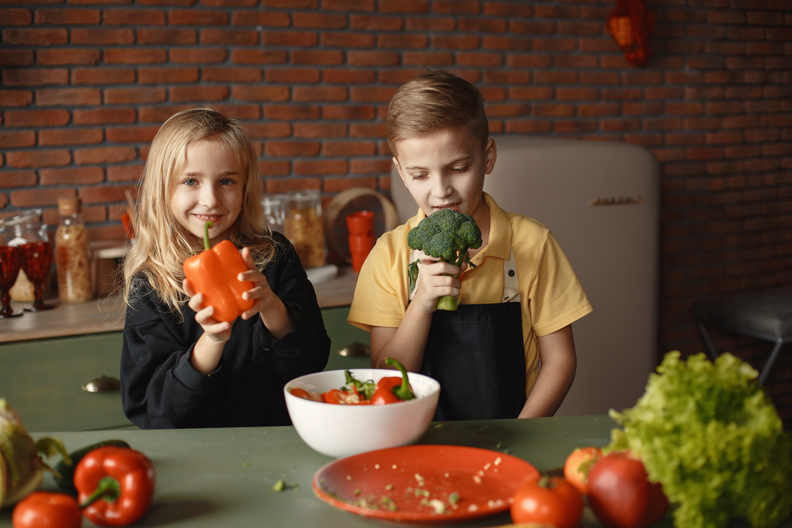 Adorable children during healthy food preparation in loft kitchen
